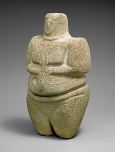 Standing female figure wearing a strap and a necklace