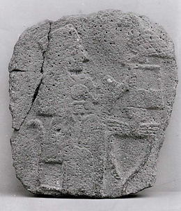 Relief: woman seated at a table