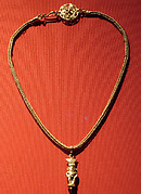 Braided chain with intricate openwork medallion at the clasp and a gold Bes pendant