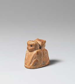 Reproduction of an ivory amulet with two apes seated back to back