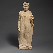 Limestone statuette of a boy holding a bird