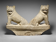 Limestone finial of a funerary stele with two seated lions
