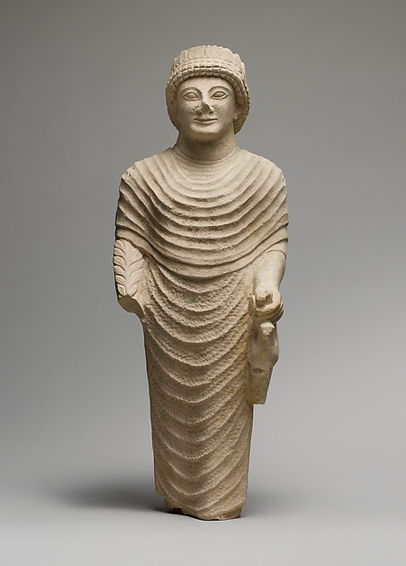 Limestone statue of a male votary holding a bird in the left hand