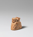 Reproduction of an ivory amulet with two apes seated back to back