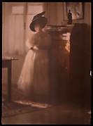 [Lady in White Dress Leaning Against Desk]