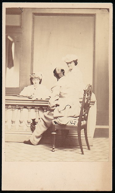 [Man, Seen from the Back, Conversing with Two Woman]