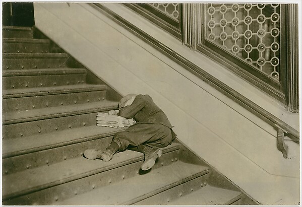 Newsboy asleep on stairs with papers, Jersey City, New Jersey