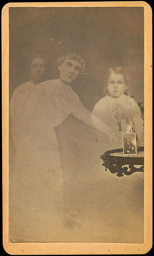 [Three Spirits with Photograph on Table]