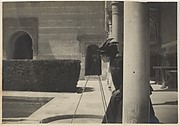 [View of a Courtyard with a Woman (Olga?) Looking Through a Camera on a Tripod]