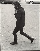 [Street Scene: Man in Boots Walking and Adjusting His Collar, New York City]