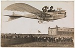 [Couple Flying Airplane Over Crowd]