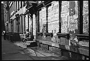 [View Down Street in Hell's Kitchen with Children on Stoop and Torn Circus Posters, New York City]