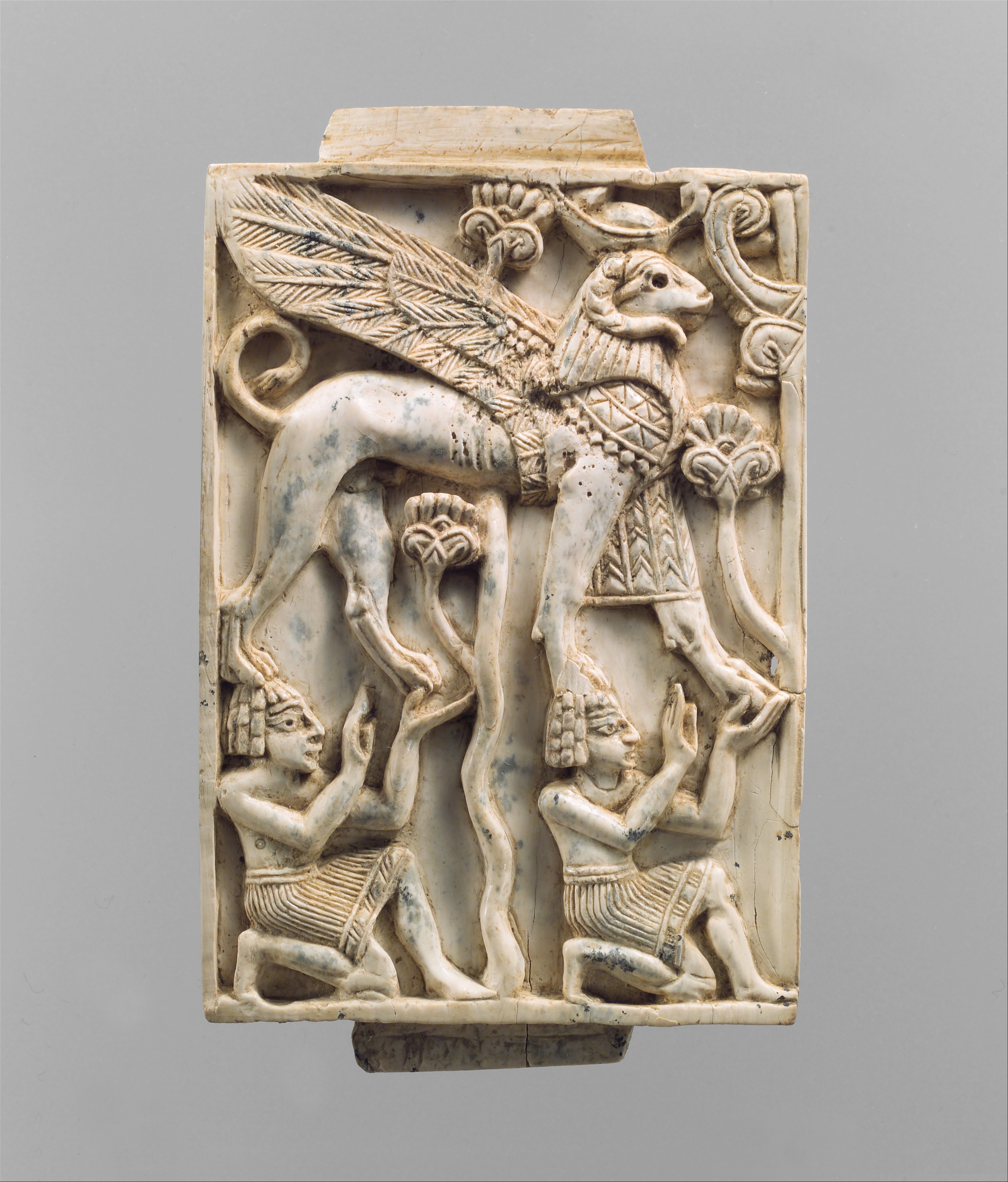 Furniture plaque carved in relief with a striding, ram-headed 
