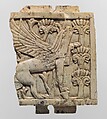 Furniture plaque carved in relief with a griffin in a floral landscape, Ivory, Assyrian