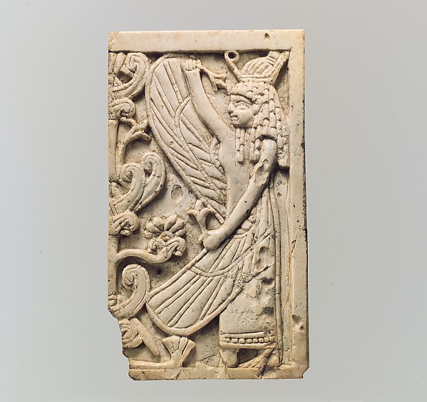 <bdi class="metadata-value">Furniture plaque carved in relief with a winged female figure and a “sacred tree” 3.13 x 1.83 in. (7.95 x 4.65 cm)</bdi>