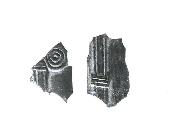 Relief fragments a) H. 2.6 cm x W. 1.5 cm x Th. .4 cm b) H. 2.1 cm x W. 1.5 cm x Th. .4 cm