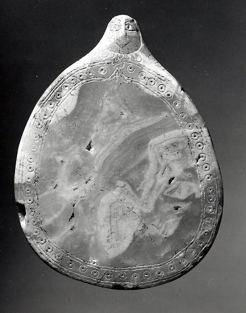 Palette with a sculpted female head and incised decoration 5 1/4 x 3 7/8 in. (13.2 x 9.9 cm)