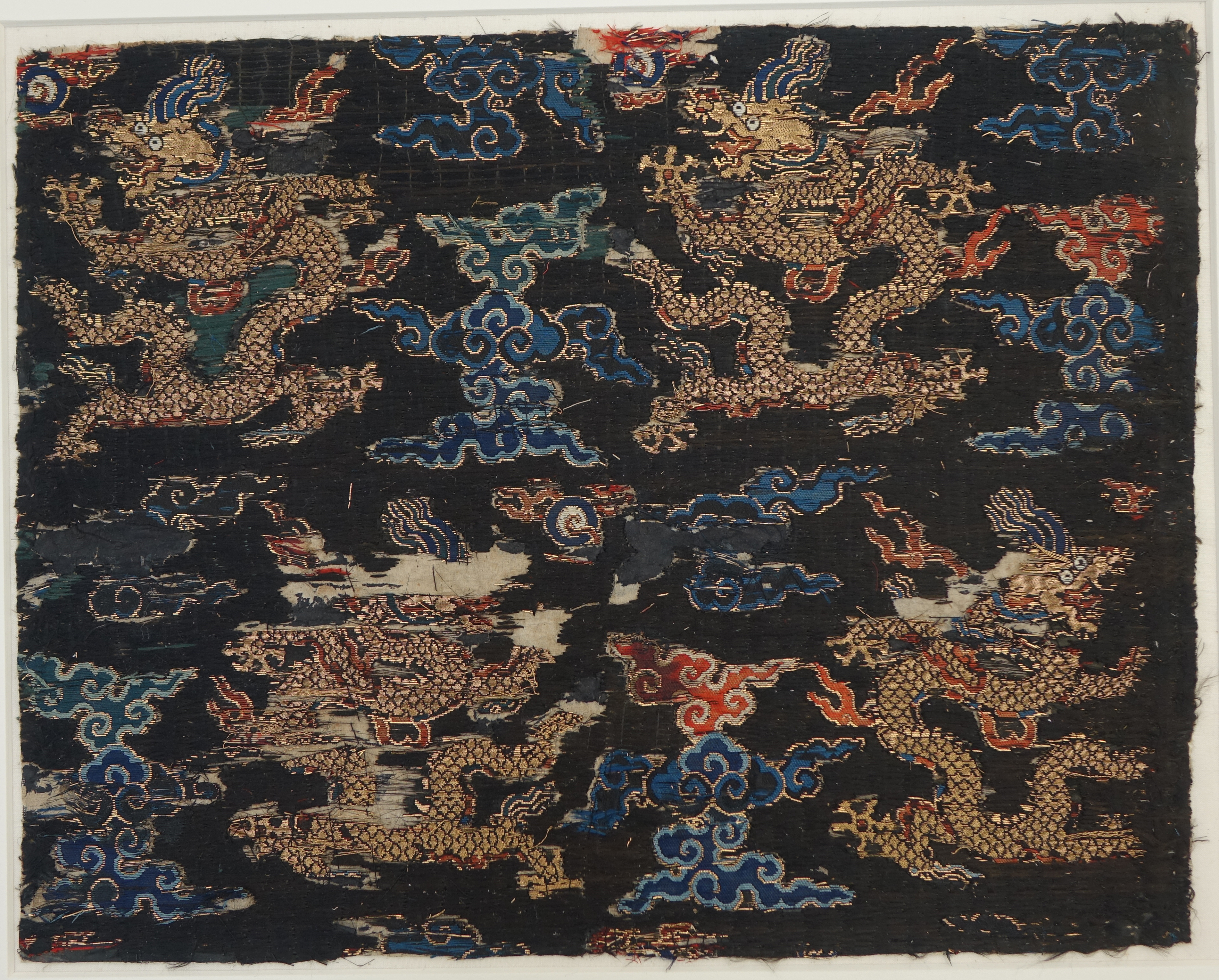 Textile fragment with dragons amid clouds