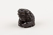 Netsuke of Seated Shishi Clutching a Ball, Ryōzan (Japanese), Ebony with gold and horn inlay, Japan