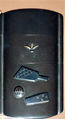 Case (Inrō) with Symbols of Girls' Festival (obverse); Emblems for New Year Festival (reverse), Metal, dark silver metal ground, applied silver and gold metals; Interior: black lacquer and silver metal, Japan
