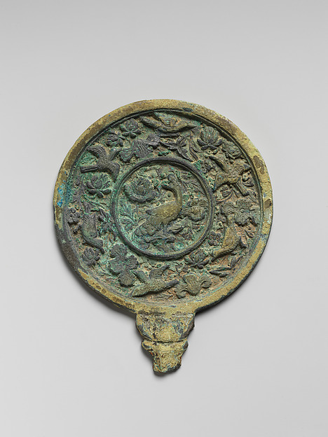 Mirror with handle and decorated with peacock, flowers, and birds