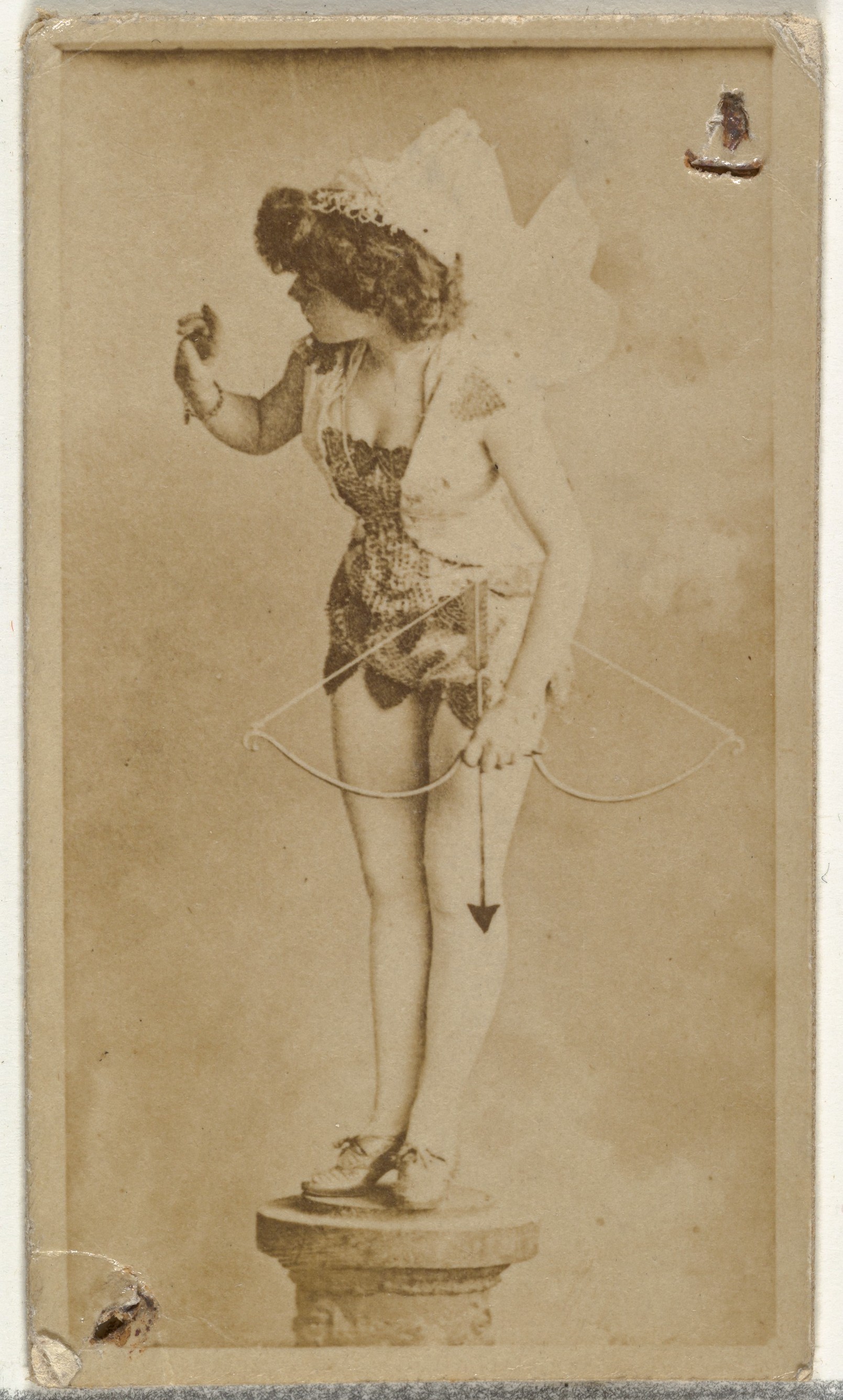 [Actress dressed as cupid perched on prop column], from the Actors and Actresses series (N145-8) issued by Duke Sons & Co. to promote Duke Cigarettes