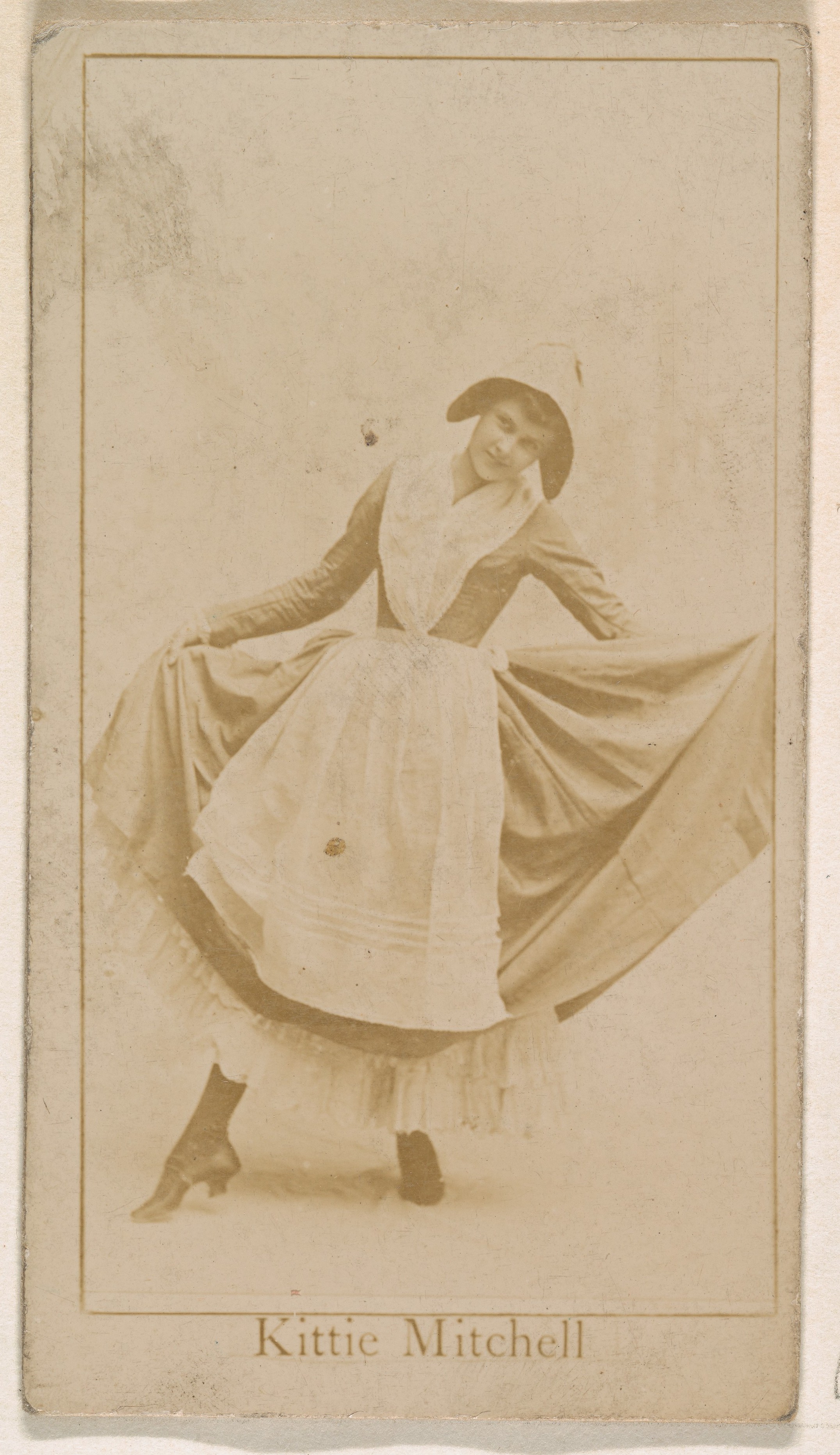 Kittie Mitchell, from the Actresses series (N245) issued by Kinney Brothers to promote Sweet Caporal Cigarettes