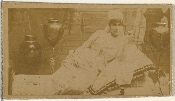 [Reclining actress surrounded by vases], from the Actors and Actresses series (N145-8) issued by Duke Sons & Co. to promote Duke Cigarettes