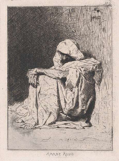 An Arabic man seated on the ground, head partly covered