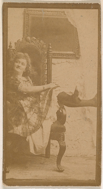 Actress posing on chair with legs resting on armrest, from the Actresses series (N664) promoting Old Fashion Fine Cut Tobacco
