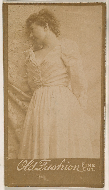 Actress leaning against studio curtain, from the Actresses series (N664) promoting Old Fashion Fine Cut Tobacco