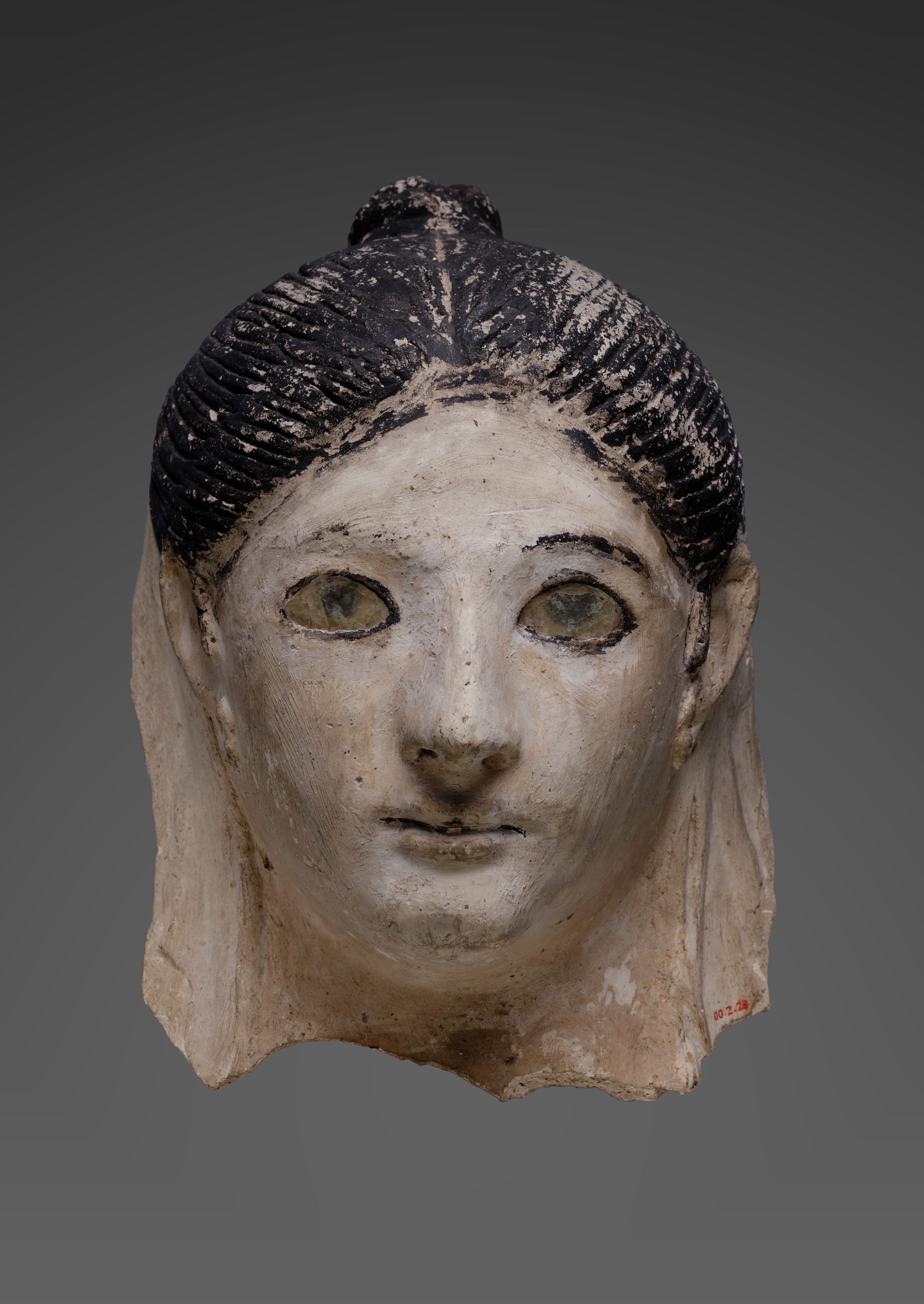 Mask of a woman with her hair in a small knot