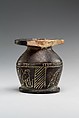 Kohl jar decorated wtih Horus falcon and grotesque figure, Blackened limestone