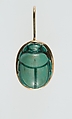 A modern pendant setting holding an inscribed scarab, Glazed steatite, gold