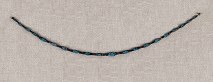 String of black faience beads with encrustations, Blue and black faience