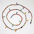 String of tiny disk beads, barrels, and 13 Taweret amulets, Gold, glass, carnelian