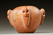 Piriform macehead with male faces, Limestone (pink), organic material