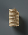 Wig (a) and nemes tail (b), indurated limestone