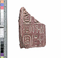 Part of a small block with names of the Aten preserved on opposite sides and names of Akhenaten and Nefertiti on one preserved end, Red quartzite