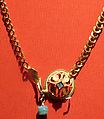 Chain terminating in a leaf motif, and having a raised openwork clasp ornament, gold, blue stone, emerald