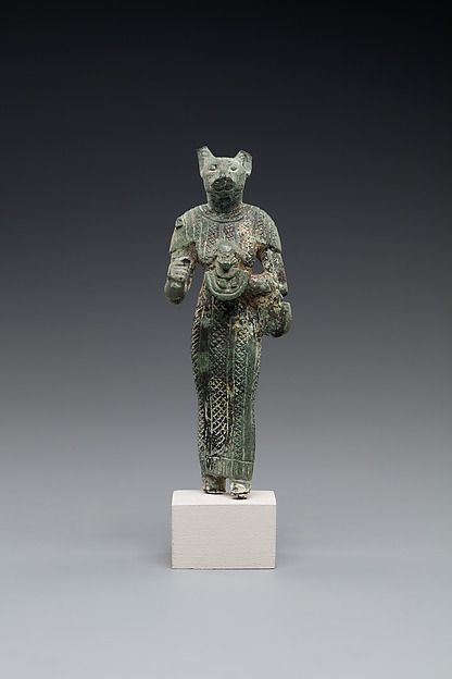 Bastet holding a lion-headed aegis, a sistrum (broken), and a basket
