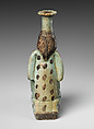 Faience double-spouted vessel in the form of a kneeling woman holding a jar, Faience, East Greek