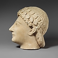 Limestone head of a beardless male votary with a wreath of leaves, Limestone, Cypriot