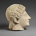 Limestone head of a beardless male votary with a wreath of leaves, Limestone, Cypriot