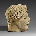 Limestone head of a beardless male votary with a wreath of leaves, Limestone, Cypriot