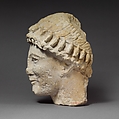 Limestone head of a beardless male with a wreath of flower buds, Limestone, Cypriot