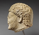 Limestone head of a bearded male with a wreath of leaves, Limestone, Cypriot