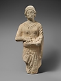 Limestone statuette of a female votary holding pieces of fruit, Limestone, Cypriot