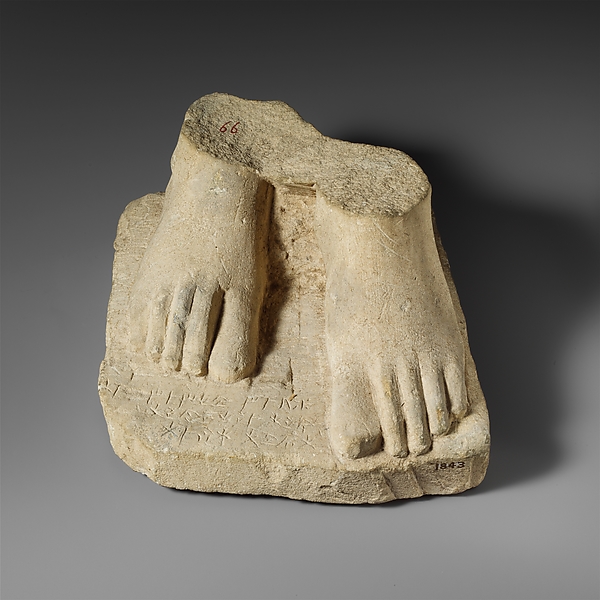Limestone plinth with the feet of a male statuette