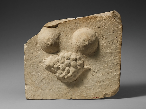 Limestone plaque with breasts and a bunch of grapes in relief by an unrecorded maker, The Metropolitan Museum of Art
